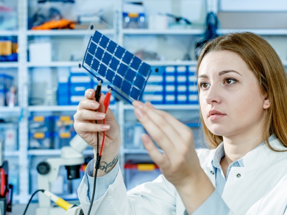 Student holding up a photovoltaic cell