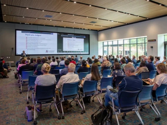 An image of a person giving a presentation to a room full of people.